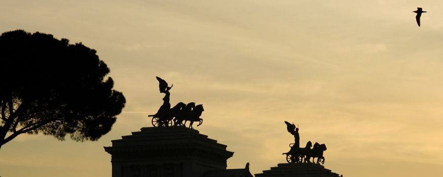 Silhouetted Vittorio Emanuele II monument at sunset, Rome, Italy.