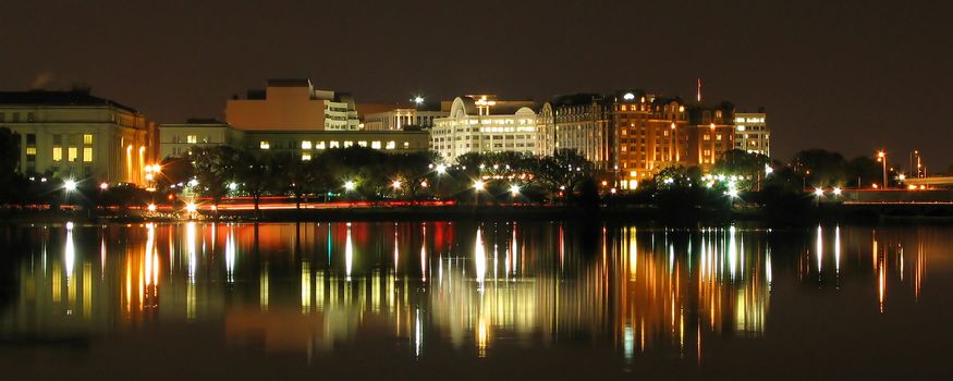 Night scene of Washington D.C, with lights reflecting on Potomac river in foreground, U.S.A.