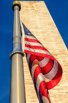 Low angle view of Washington Monument and American Flag, Washington DC, USA