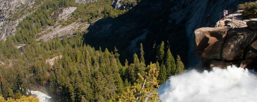 Scenic view of cascading waterfall in Yosemite National Park with forest in background, California, U.S.A.