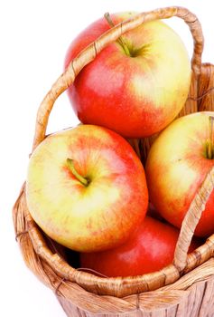 Delicious Ripe Red and Yellow Apples in Wicker Basket closeup on white background