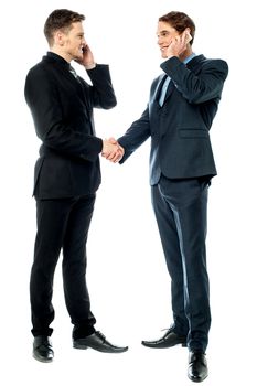 Colleagues shake hands during phone calls