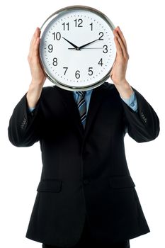Man holding wall clock in front of his face