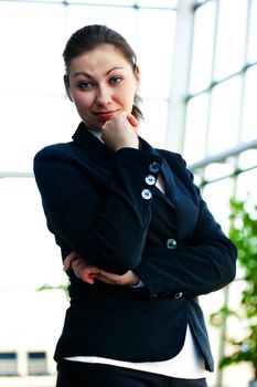 Portrait of successful business woman smiling on the background of a blurred office interior