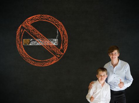 Thumbs up boy dressed up as business man with no smoking chalk sign on blackboard background