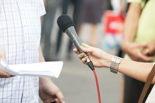 A journalist is making a interview with a microphone