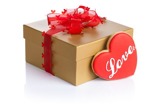 Golden gift box with love cookie in shape of heart on white background. Composition for Valentines Day