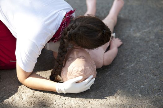 CPR practitioner examining airways on dummy