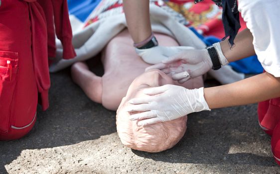 Paramedic demonstrates CPR on dummy