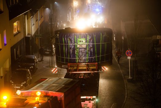 OSTFILDERN-SCHARNHAUSEN, GERMANY - DECEMBER 12, 2013: A heavy tunnel digging machinery is loaded on a flatbed trailer and carried to the construction site of Stuttgart 21 at night on December 12, 2013 in Ostfildern-Scharnhausen near Stuttgart, Germany. S21 is one of the most expensive and controversial railway projects ever with regular demonstrations against the plans to move the existing station underground going on.