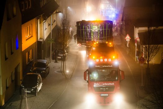 OSTFILDERN-SCHARNHAUSEN, GERMANY - DECEMBER 12, 2013: A heavy tunnel digging machinery is loaded on a flatbed trailer and carried to the construction site of Stuttgart 21 at night on December 12, 2013 in Ostfildern-Scharnhausen near Stuttgart, Germany. S21 is one of the most expensive and controversial railway projects ever with regular demonstrations against the plans to move the existing station underground going on.