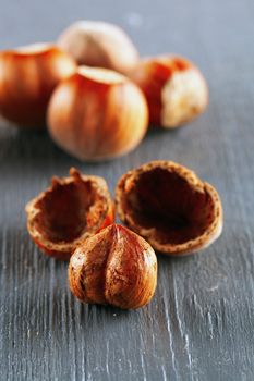 Some hazelnuts over a gray wooden table