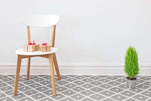 Presents on an elegant white chair, and little green cypress tree.