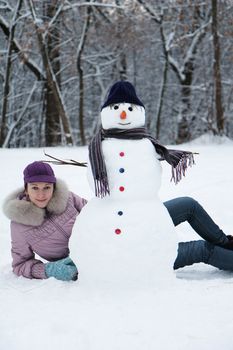 Beautiful brunette near a snowman