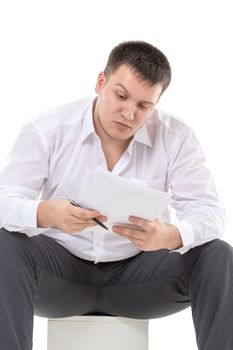 Businessman reading a report with scepticism raising his eyebrow in disbelief at the information