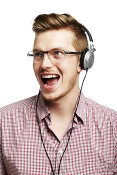 Young man listening to music and singing with headphones. Isolated on white. 