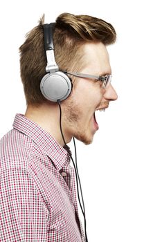 Young man listening to music and singing with headphones. Isolated on white. 