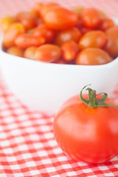 cherry tomatos and tomatos in bowl on checkered fabric