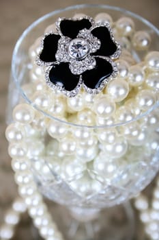 Black and diamond ring in a glass of pearls