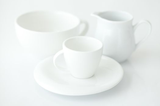 white cup with saucer and milk jug 