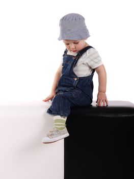 Little boy sitting on the black and white cubes