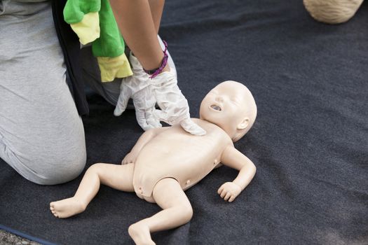 Paramedic demonstrates CPR on infant dummy