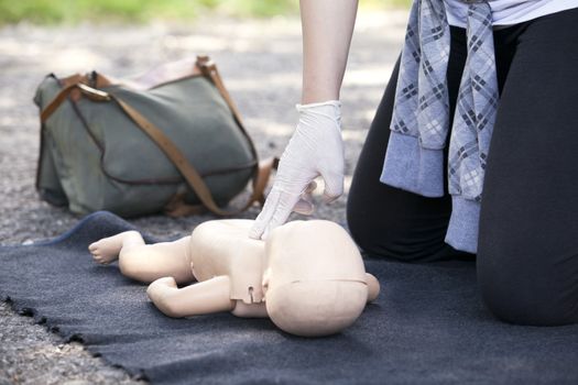 Paramedic demonstrates CPR on infant dummy