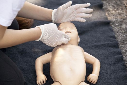 Paramedic demonstrates CPR on infant dummy