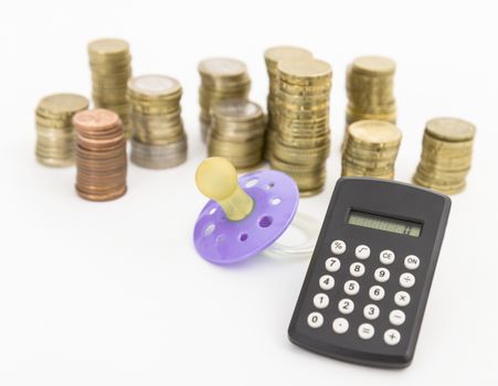 pacifier with hard money and small pocket calculator in light background.