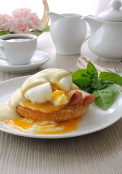  Breakfast of boiled eggs (poached) with ham on a bun with mustard sauce