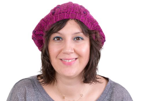 Attractive woman wearing a knitted purple winter hat looking at the camera with a bright friendly smile, isolated on white