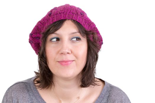 Thoughtful woman wearing a knitted purple winter cap smiling in anticipation of being able to realise her dreams, looking off with her eyes to the side and smiling, isolated on white