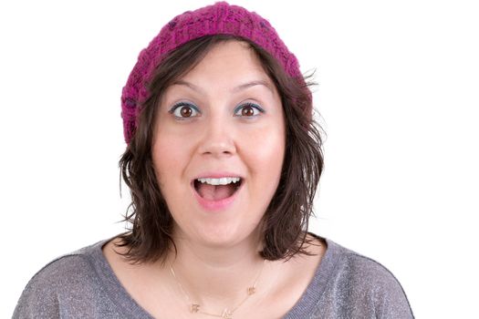 Attractive woman in a knitted cap reacting in delight and pleasure with sparkling eyes and her mouth open wide, isolated on white
