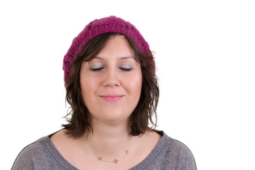Woman wearing a purple knitted cap with an expression of pure bliss smiling in ecstasy with her eyes closed isolated on white