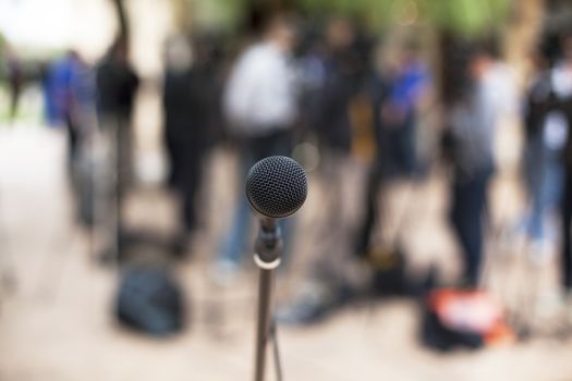 Microphone in focus against blurred audience