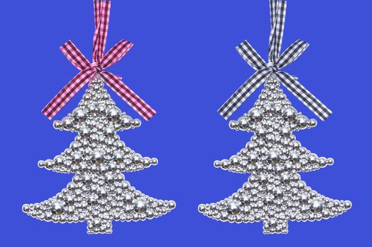 Two silver Christmas tree - decoration isolated on blue  background
