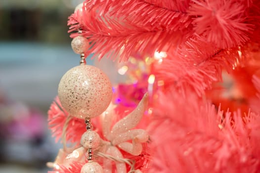 Pink christmas decorations and lights hanging on a pink Christmas tree