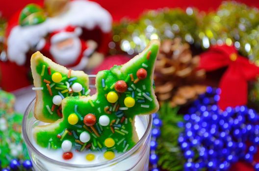 homemade gingerbread christmas tree cookies and milk with seasonal background