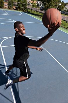A young basketball player driving to the hoop with some fancy moves. Shallow depth of field.