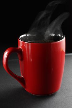 Red cup of coffe on a dark background