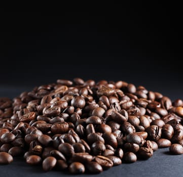 A lot of roasted coffee beans at dark background