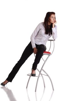 Girl sitting on the bar chair at white background