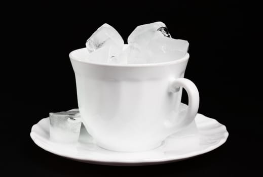 Ice cubes inside a cup at the dark background