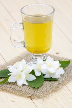 glass of jasmine tea and jasmine flowers
