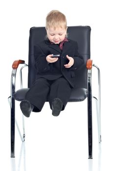 Little businessman with a phone on a chair