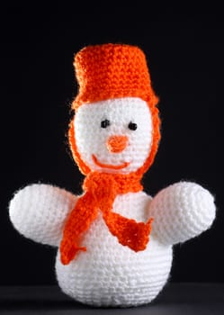White snowman made from threads at the dark background
