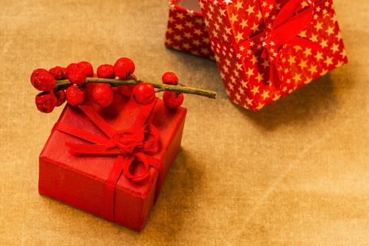 Red present boxes and berries on golden background