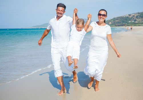 Photo of happy family running on the beach