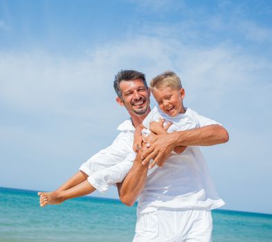 Father and son having fun on tropical beach