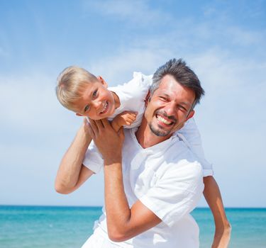 Father and son having fun on tropical beach